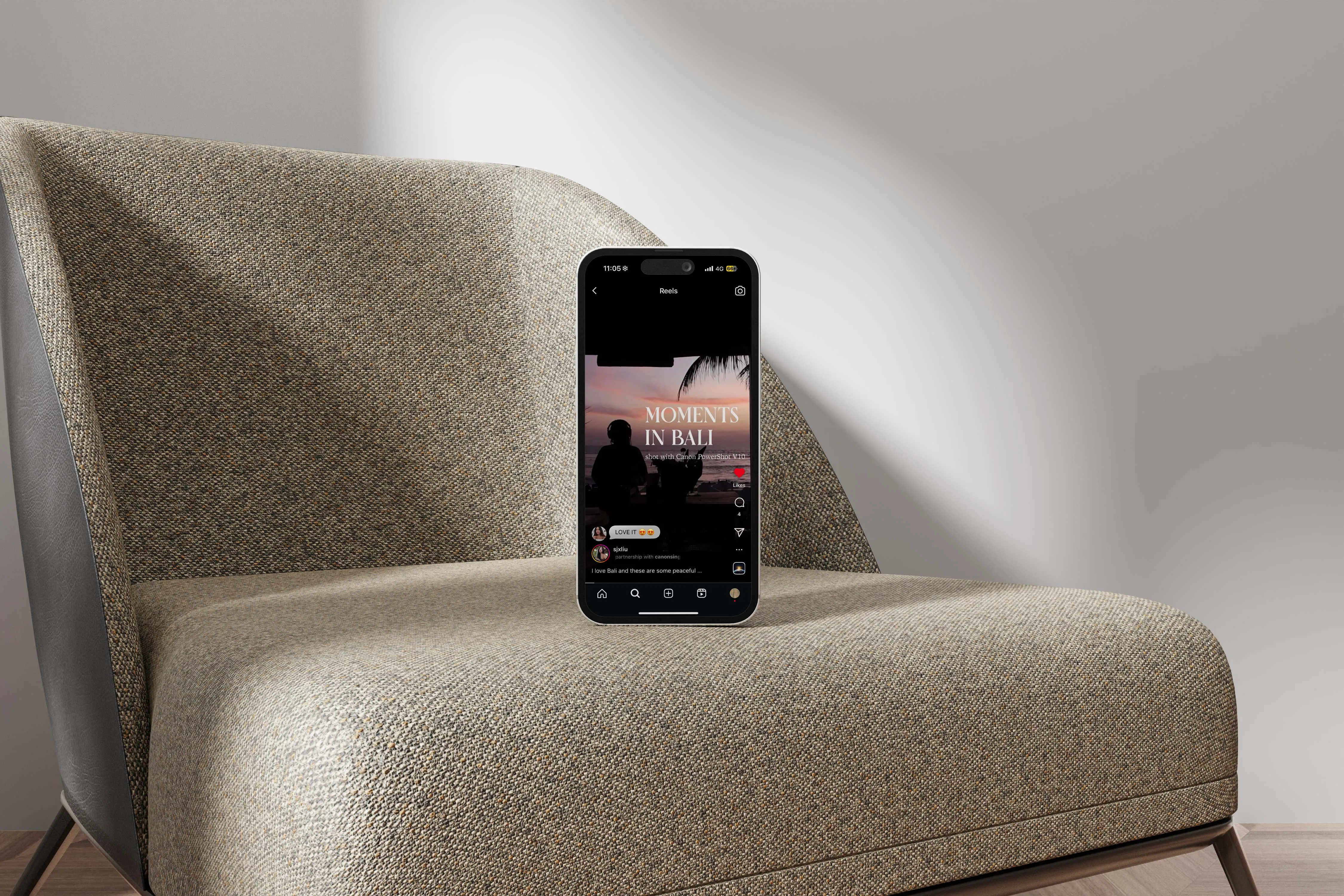 Phone showing the Canon PowerShot V10 reel, propped on a boucle armchair