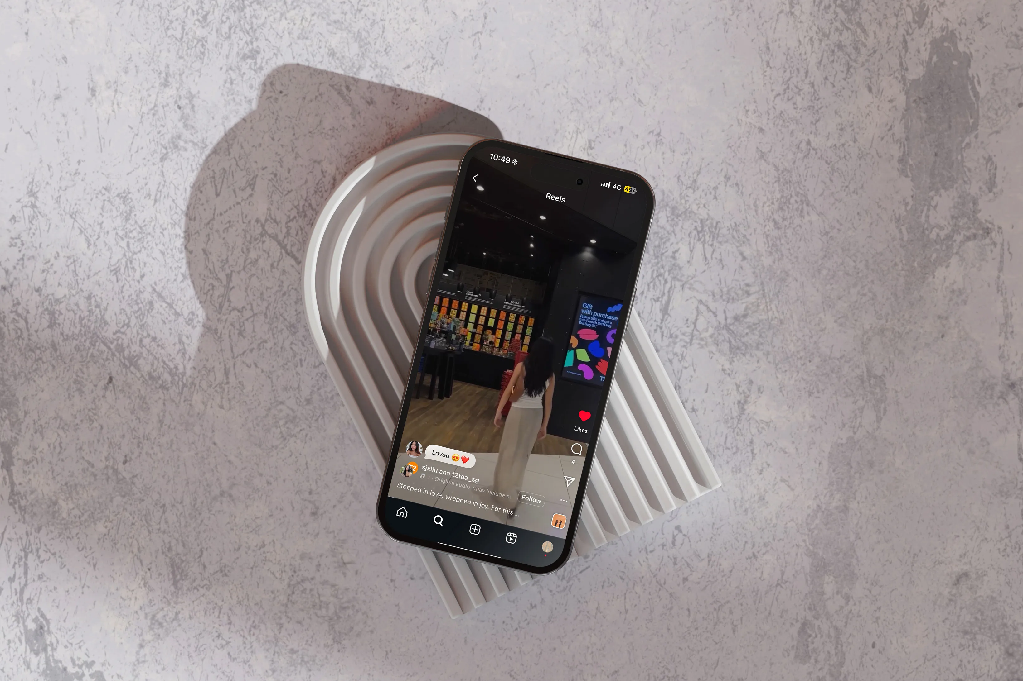 Phone showing T2 Tea’s Lunar New Year reel, resting on a ridged stone tray
